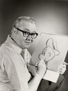 A cartoonist, Walt Kelly, sketching on his sketch pad
