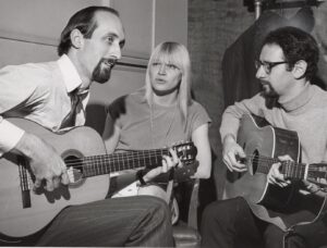 3 musicians, Peter Paul and Mary. Peter and Paul are playing the guitar and Mary is in the middle
