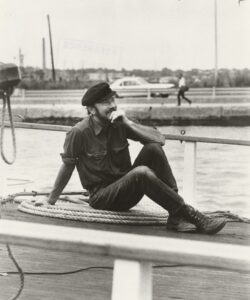 Pete Seeger sitting on a boat dock