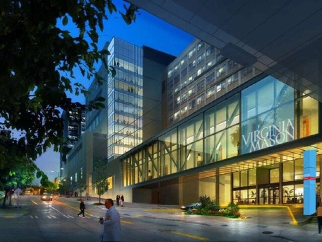 A night-time street scene with a glass building in the background.