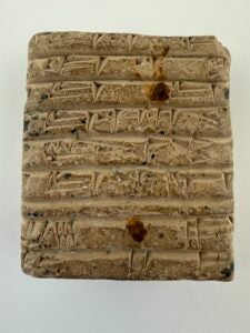 Small rectangular cuneiform tablet on a white background.