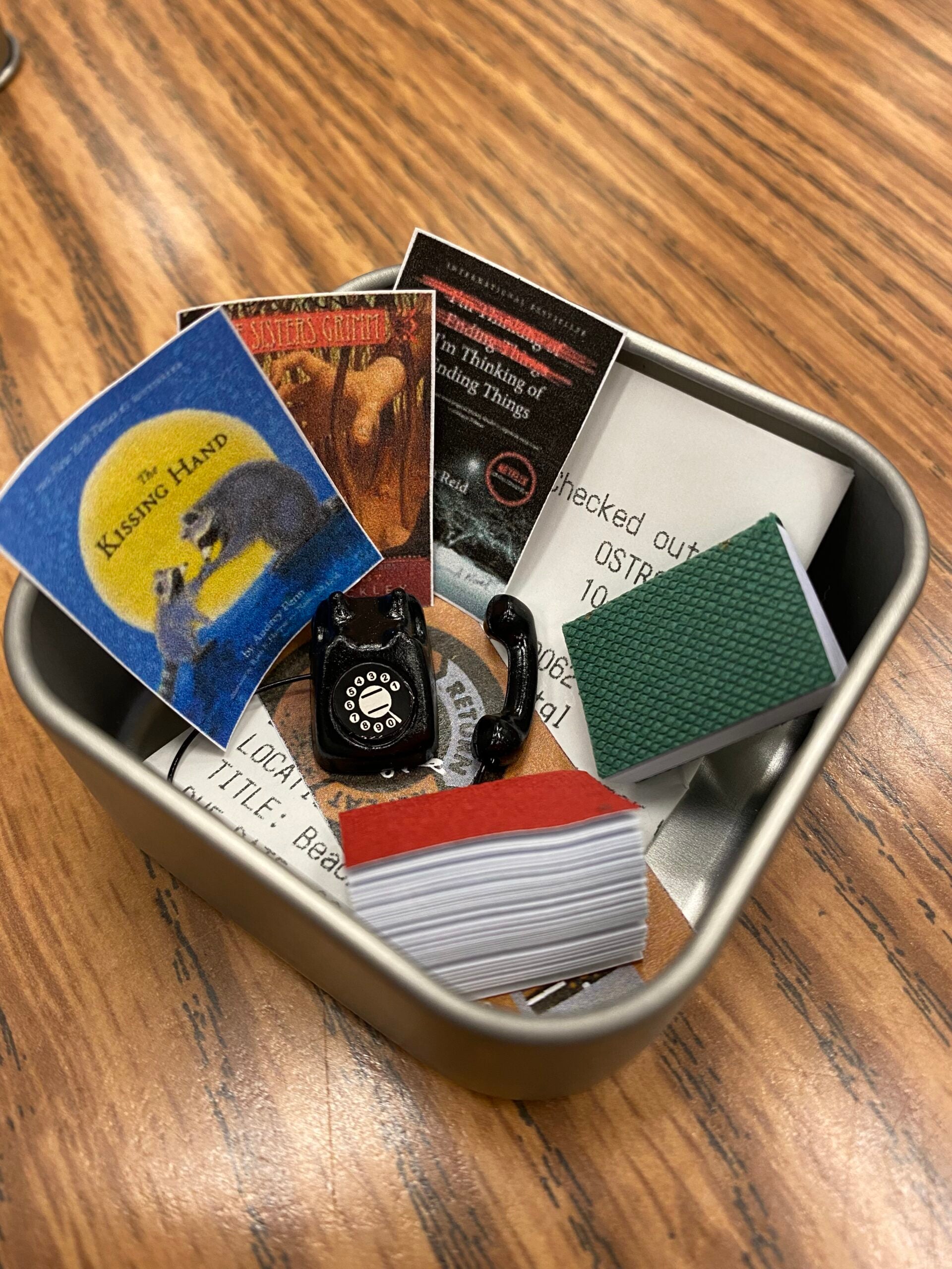 Tin with library related items inside.