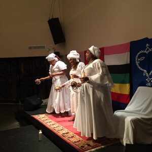 Swearing-in ceremony of the first ever GwètòDe's for the Haitian diaspora by Konfederasyon Nasyonal Vodouyizan Ayisyen (KNVA) held 2/25/2017 at National Black Theatre in Harlem NYC. GwètòDe's are the clergy of Haitian Vodou, representing the interests of Haitian vodouyizan in a specific geographic region. In this ceremony GwètòDe's were sworn in for the state of New York (Manbo Florence Jean-Joseph, pictured center), the state of Massachusetts (pictured left) and for Canada (Manbo Fabiola Abelard, pictured right). KNVA is a Haiti-based organization that designates the Ati National, the head of Haitian Vodou and all of the vodou clergy, for certification by the Haitian government. The Haitian Constitution of 1987 gave Vodouyizan the same rights as practitioners of other faiths.