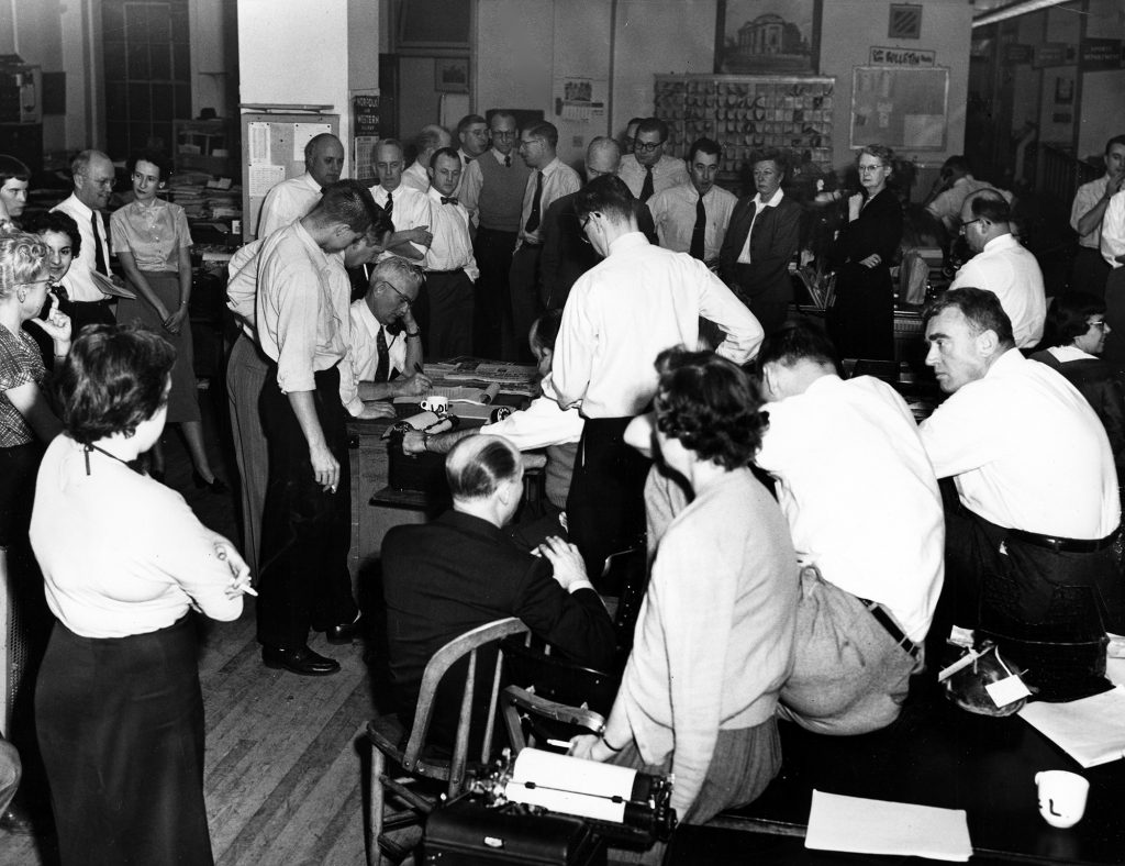 Press reporters and editors gather in the newsroom to hear the jury's verdict in the Sam Sheppard murder case in 1954. Sheppard was found guilty and later sentenced to life in prison, which was overturned on appeal. Special Collections, Cleveland State University Library.