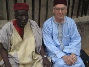 2 men, seated, wearing baba riga (formal attire of Hausa men)